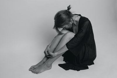 Sitting on the floor of the woman in black
